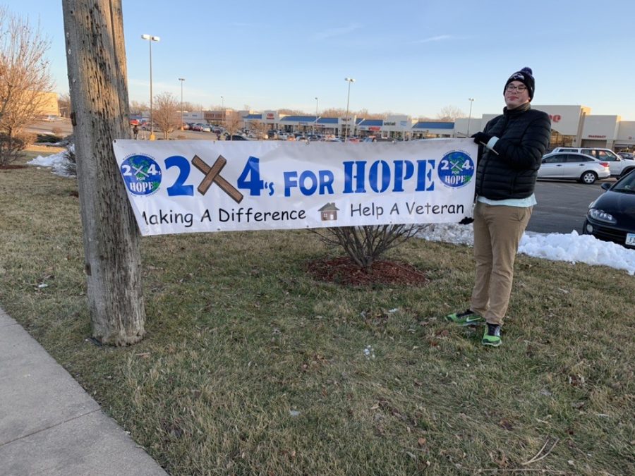 Sophomore+Brandon+Collins+with+the+banner+for+2x4s+for+Hope.+