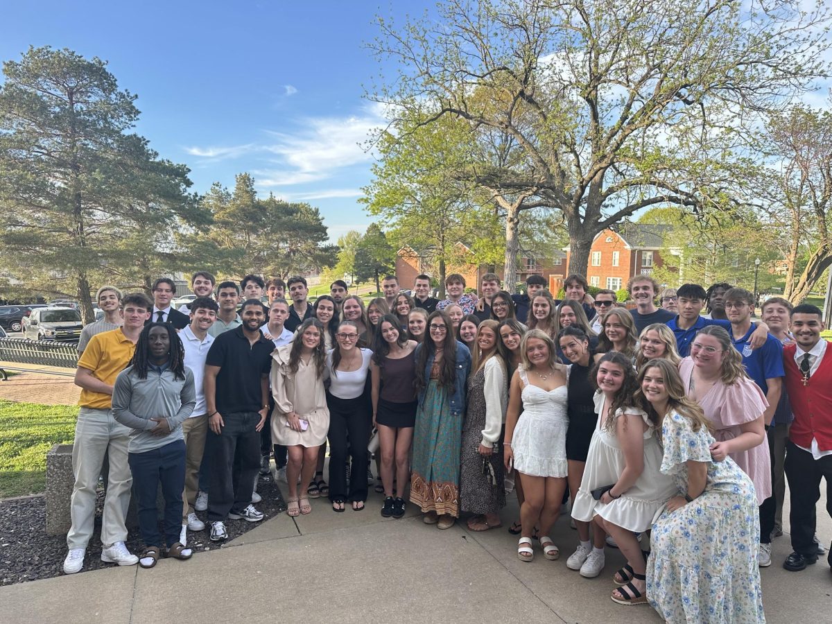 Hoffman (in green in front middle) poses with the men's and women's soccer players she works with. 