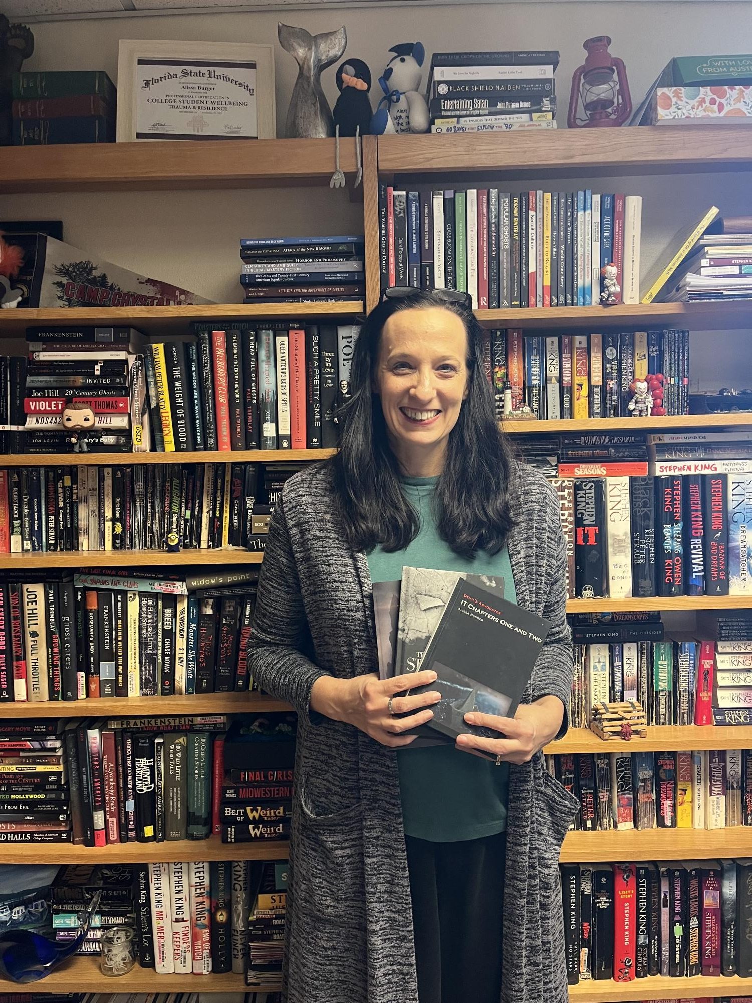 Burger poses with her three published books on Stephen King