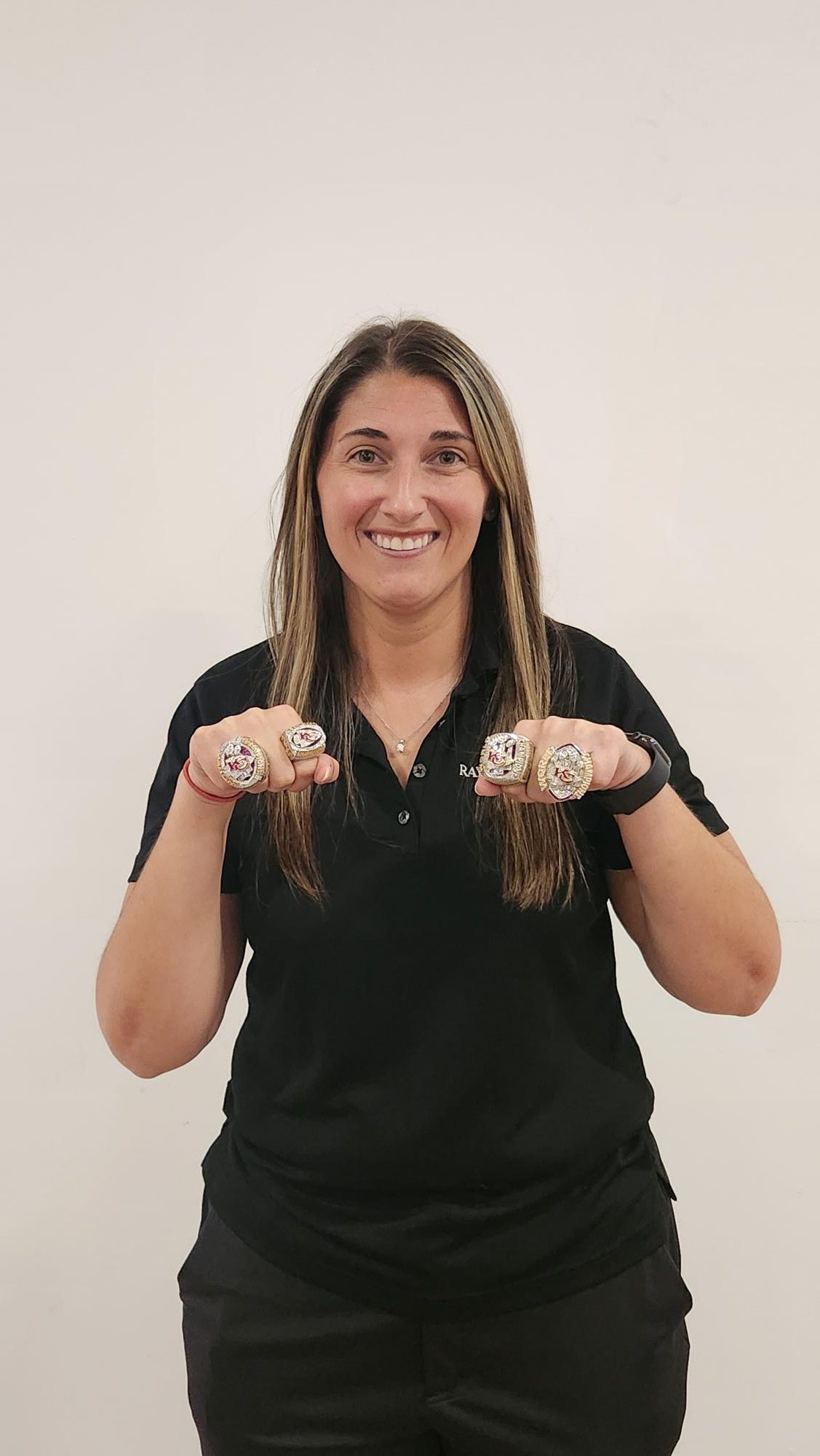 Abbey Kortz posing with her Super Bowl rings.